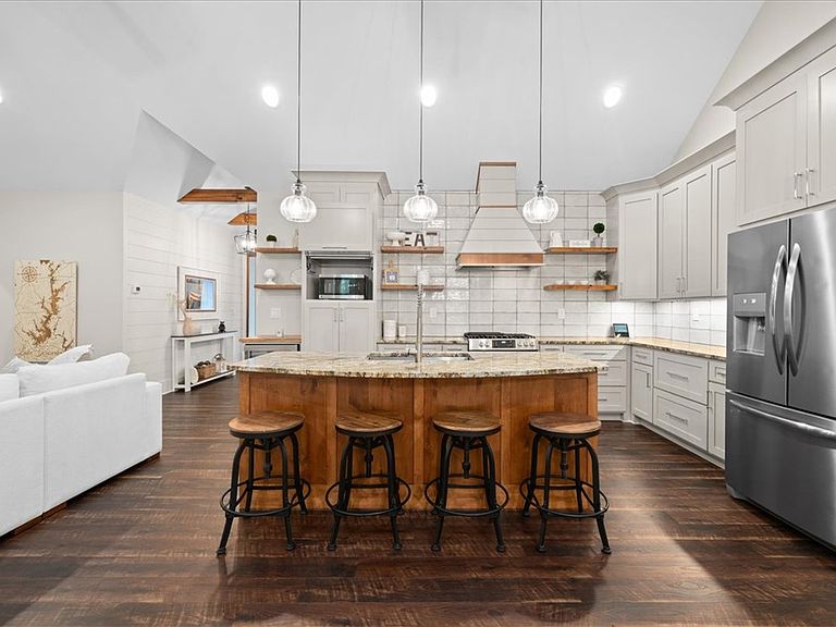 Kitchen island at 107 Cedar Bluff with a single stainless basin sink, granite countertop, three glass pendant lights overhead, and Frigidaire Gallery stainless appliances behind